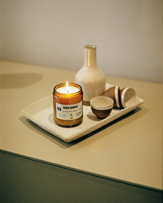 Thomas Street Herb Garden Candle on a tray with ceramic items on a neutral background